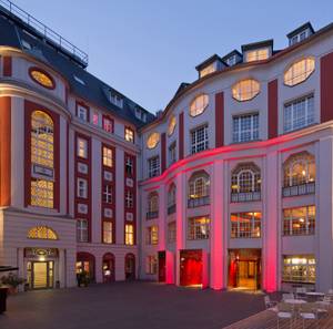 Admiralspalast Berlin bei Nacht mit rot beleuchtetem Theatereingang im Innenhof