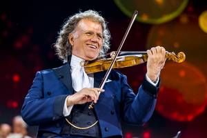 André Rieu spielt lächelnd Geige bei Konzert auf dem Vrijthof in Maastricht