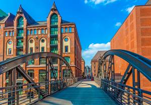 Backsteinbrücke mit Bogen in der Speicherstadt Hamburg bei blauem Himmel