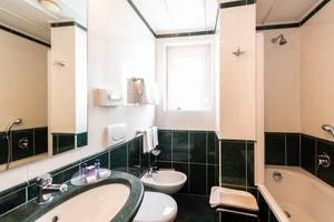 Badezimmer mit Bidet, Badewanne und grünen Fliesen im Hotel Milan Speranza