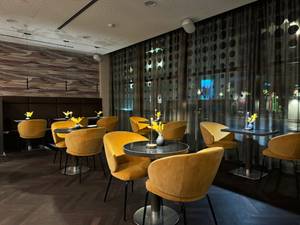 Bar-Lounge im Hotel Arcotel Onyx Hamburg mit gelben Sesseln und Vorhang