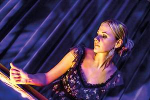 Besucherin in Abendkleid im Sandtheater Dresden bei stimmungsvoller Lichtshow