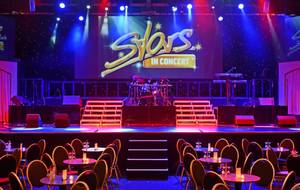 Bühne der Show „Stars in Concert“ im Estrel Berlin mit Lichtshow und Zuschauertischen
