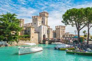 Burg Rocca Scaligera mit Booten im türkisblauen Wasser, Sirmione am Gardasee