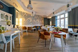 Café-Lounge im Hotel Drei Inseln mit Wellen-Wandmotiv und gemütlichen Sitzecken