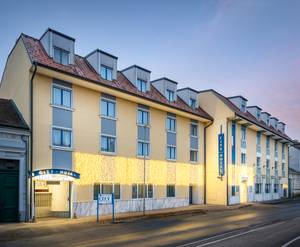 City Hotel Stockerau: Außenansicht der Hotelfassade in der Abenddämmerung