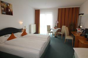 Doppelzimmer im H+ Hotel Erfurt mit Sitzecke, Schreibtisch und großem Fenster
