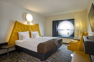 Doppelzimmer mit gelbem Kopfteil im Hotel Arcotel Onyx Hamburg