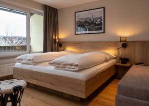 Doppelzimmer mit Holzbett und Blick zum Fenster, Hotel zur Post Rohrsdorf