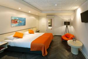 Doppelzimmer mit orangefarbener Bettwäsche im Fletcher Hotel Oud London
