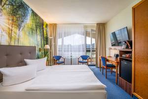 Doppelzimmer mit Waldwandmotiv, Schreibtisch und TV im AHORN Berghotel Friedrichroda