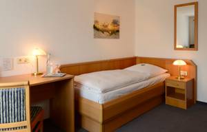 Einzelzimmer im Hotel Goos mit Schreibtisch, Nachttisch und Strandbild