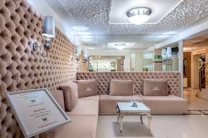 EleganterAufenthaltsraum mit gepolsterter Sitzecke, Kristalllampen und Spiegelwand im Hotel Perełka