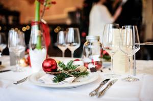 Festlich gedeckter Tisch mit Weihnachtsdeko, Weingläsern und Tannengrün