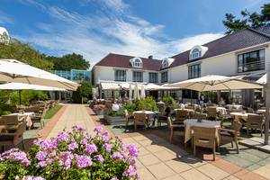 Fletcher Hotel-Restaurant Oud London – sonnige Terrasse mit Rattanmöbeln