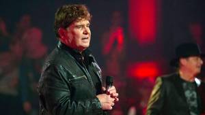 Frank Schöbel singt live auf der Bühne in schwarzer Lederjacke bei Konzert