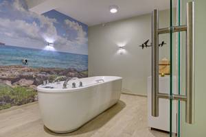 Freistehende Badewanne im Spa-Bereich Hotel Drei Inseln mit Meer-Wandbild, Swinemünde