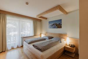 Gemütliches Doppelzimmer mit Holzbett und Bergblick im Parkhotel Matrei