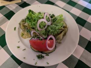 Gurkenteller mit Salat, Tomate und roten Zwiebeln im Spreewald serviert