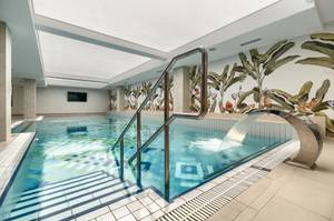 Hallenbad im Afrodyta SPA Hotel Swinemünde mit Wasserfall und Dschungel-Wandbild