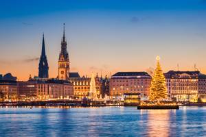 Hamburger Skyline mit Rathaus und beleuchtetem Weihnachtsbaum an der Alster