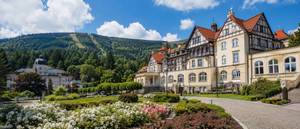 Historisches Kurhotel mit Fachwerk in Bad Flinsberg vor bewaldeten Bergen