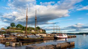 Historisches Segelschiff im Hafen von Oslo mit Festung Akershus, Norwegen