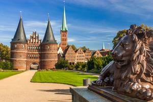 Holstentor Lübeck mit Löwenstatue und Marienkirche im Hintergrund