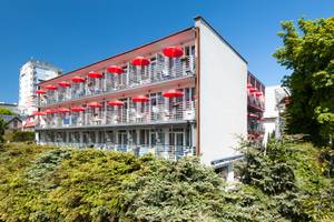 Hotel Perelka in Kolberg: Fassade mit Balkonen und roten Sonnenschirmen