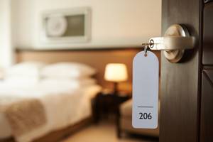 Hotelzimmer mit Zimmerschlüssel Nummer 206 an geöffneter Tür