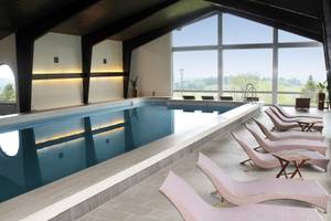 Innenpool im Hotel Schillingshof mit Panoramafenster und Liegen, Bad Kohlgrub
