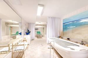 Kurbereich mit Hydrotherapie-Wanne, Behandlungsliegen und Meeresmotiv im Hotel Perelka