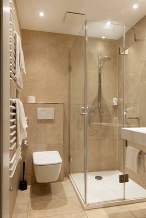 Modernes Bad mit Glasduschkabine, WC und Handtuchheizkörper im Hotel zur Post