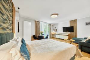 Modernes Doppelzimmer im Avangard Resort Swinemünde mit Bett, Sofa und TV