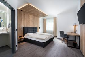 Modernes Doppelzimmer mit Holzverkleidung im City Hotel Stockerau