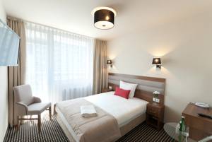 Modernes Einzelzimmer im Hotel Koral Live in Kolberg mit Doppelbett und Sitzbereich
