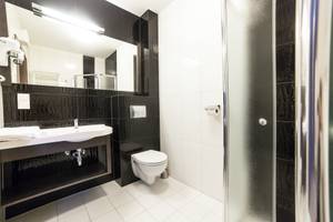 Modernes Hotelbad in Schwarz-Weiß mit Dusche im Olymp III Resort Kolberg