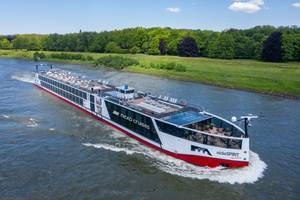 nicko SPIRIT Flusskreuzfahrtschiff auf dem Rhein mit Sonnendeck und grüner Uferlandschaft