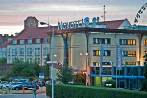 Novotel Gdansk Centrum Hotelgebäude mit Leuchtschrift bei Abenddämmerung
