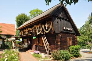 Reetgedecktes Holzhaus mit Erntekranz-Girlande am Spreehafen in Burg, Spreewald