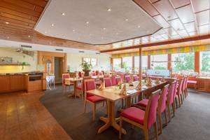 Restaurant im Hotel Südpfalz-Terrassen mit gedeckten Tischen und Panoramafenstern
