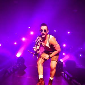 Sänger Kevin als Andreas-Gabalier-Double auf Bühne mit lila Konzertbeleuchtung