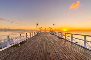 Seebrücke Misdroy bei Sonnenaufgang mit Bänken über der Ostsee