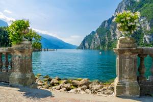 Steinbalustrade mit Blumen und Blick auf Gardasee bei Riva del Garda, Trentino