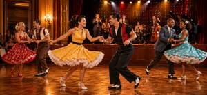 Tanzpaare im Swing-Kleid tanzen ausgelassen im Ballsaal mit Live-Band