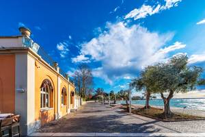 Uferpromenade in Bardolino am Gardasee mit Olivenbäumen und historischem Gebäude