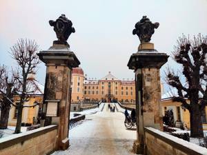 Verschneite Zufahrt zum Barockschloss Moritzburg mit Torpfeilern in Sachsen