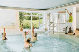 Wassergymnastik-Gruppe mit Trainer im Hallenbad des Thermenhotel Sonnenhof
