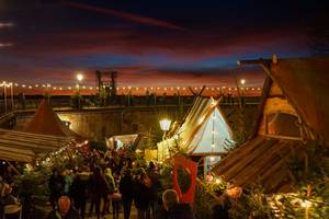 Weihnachtsmarkt Festung Königstein bei Sonnenuntergang mit Lichterketten und Besuchern
