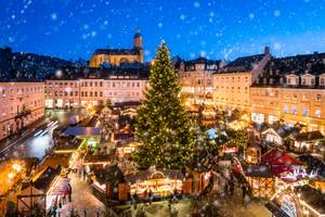 Weihnachtsmarkt in Annaberg-Buchholz im Erzgebirge mit beleuchtetem Weihnachtsbaum bei Schneefall